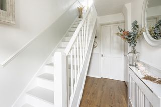 a hallway with a white painted staircase