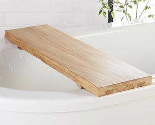 blonde wood bath caddy on a white bath tub