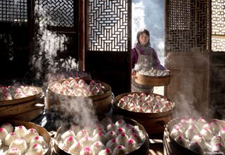 A woman makes a lot of red bean paste balls for the Lunar New Year