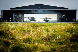 Pilots Paul Bonhomme and Steve Jones fly in formation through a hangar in Wales on April 8, 2015.