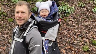 Man carrying child in Osprey Poco Plus carrier