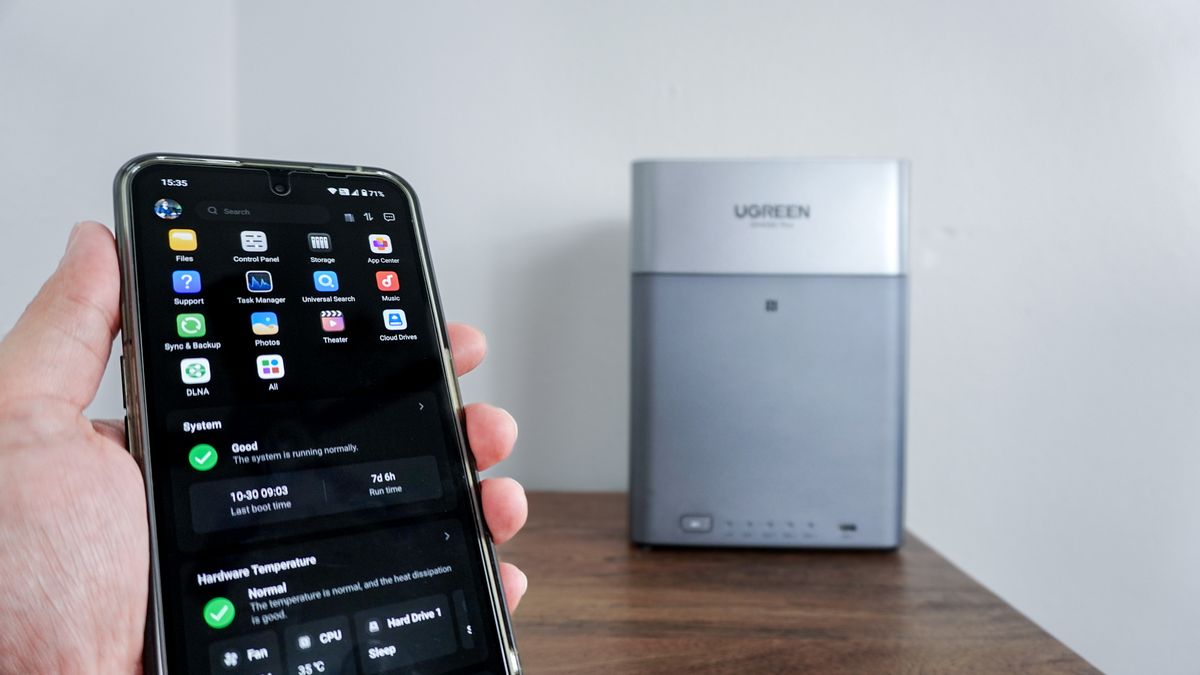A person using the Ugreen NAS app on their phone with the Ugreen NASync DH4300 Plus in the background