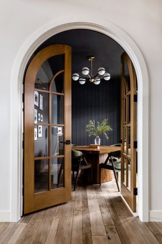 a dark painted dining room with butt and bead panelling
