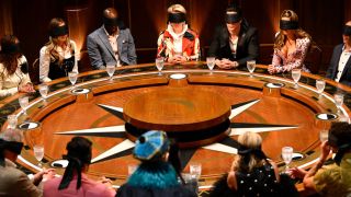 The contestants are blindfolded at the roundtable