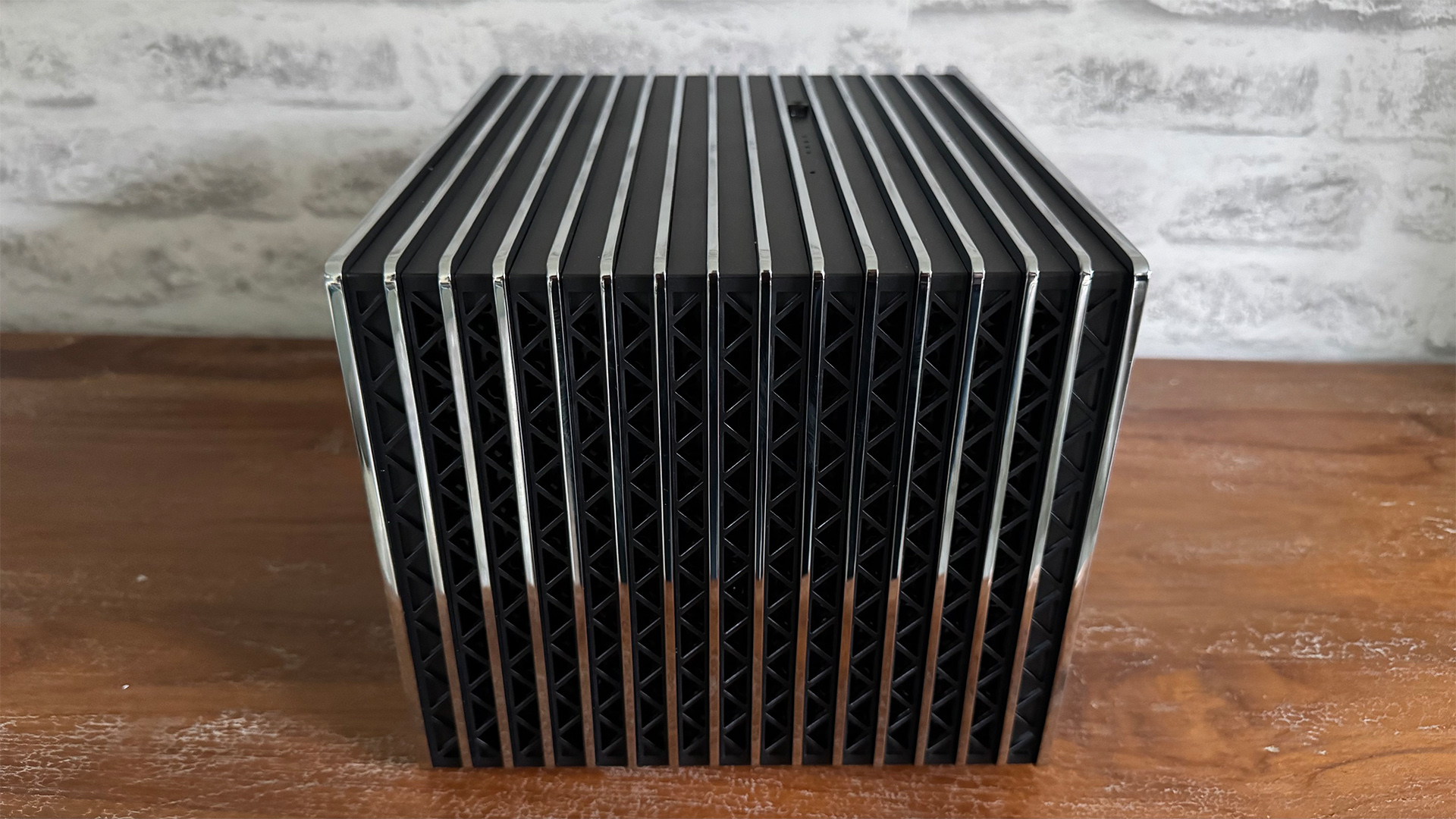 Rear of the Valerion VisionMaster Pro 2 home cinema projector on wooden sideboard in front of white brick wall