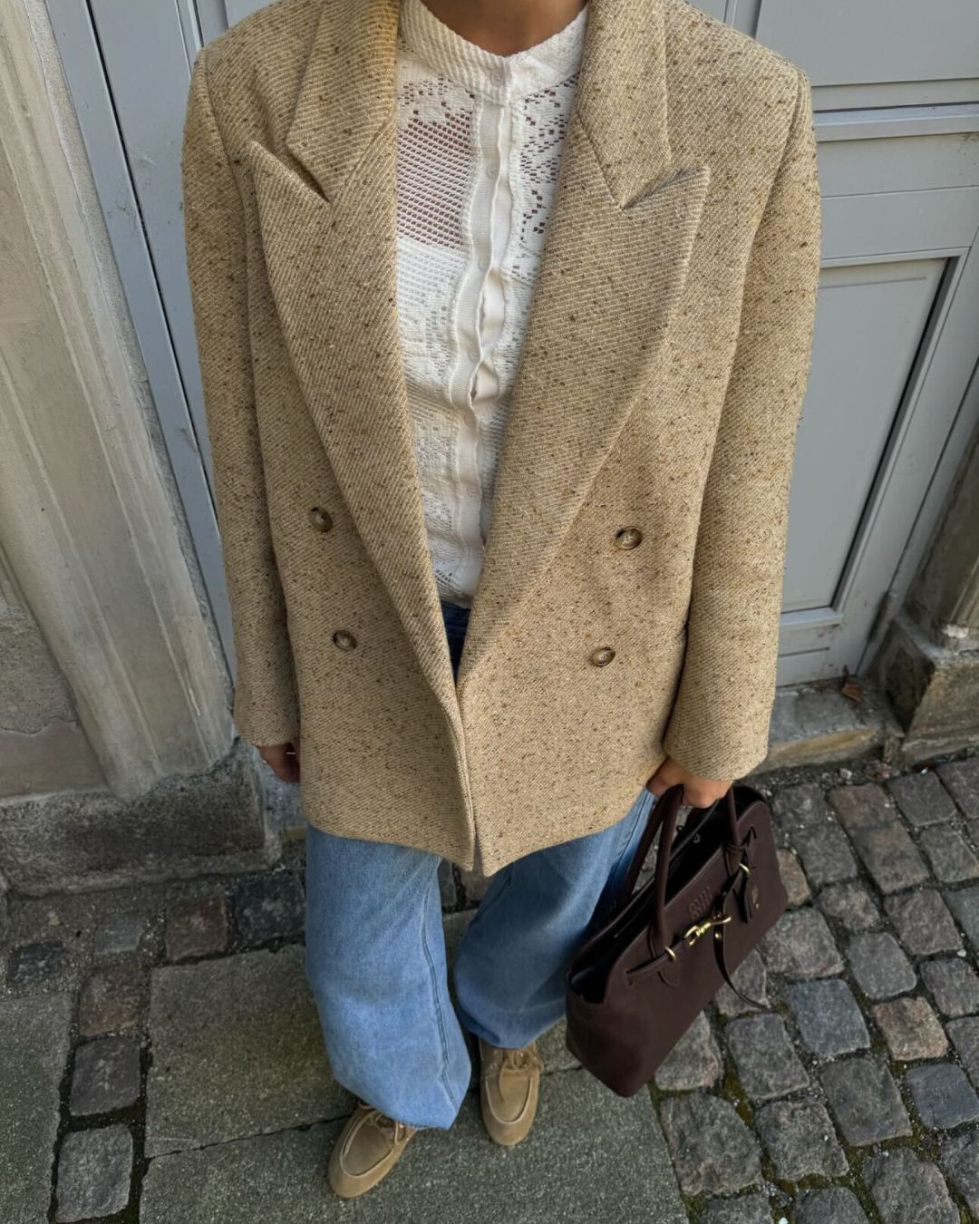 Influencer @maryljean wears a crochet cardigan underneath a wool blazer with slouchy jeans and suede coat shoes.