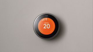 Nest Learning Thermostat on grey background