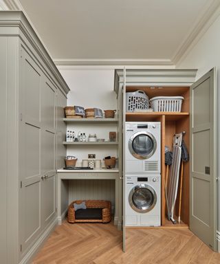 sage green utility room with a variety of different cupboards, shelving and storage