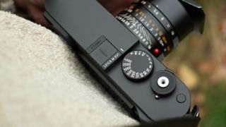 Leica M EV1 digital camera with lens attached around a person's neck with a strap