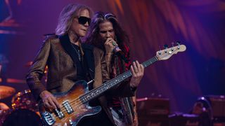 Tom Hamilton plays bass onstage with Steven Tyler