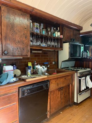 A dated galley kitchen with dark wooden cabinetry