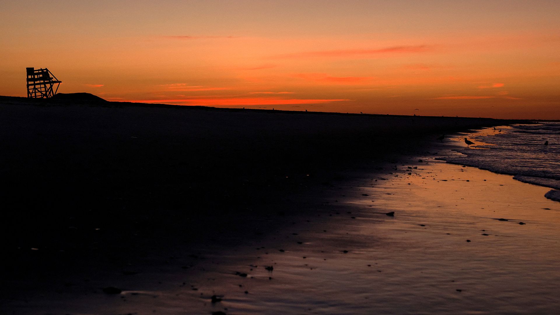 Lifeguard chairs stand stacked at sunrise, marking the end of summer supervision, at Lido Beach, New York