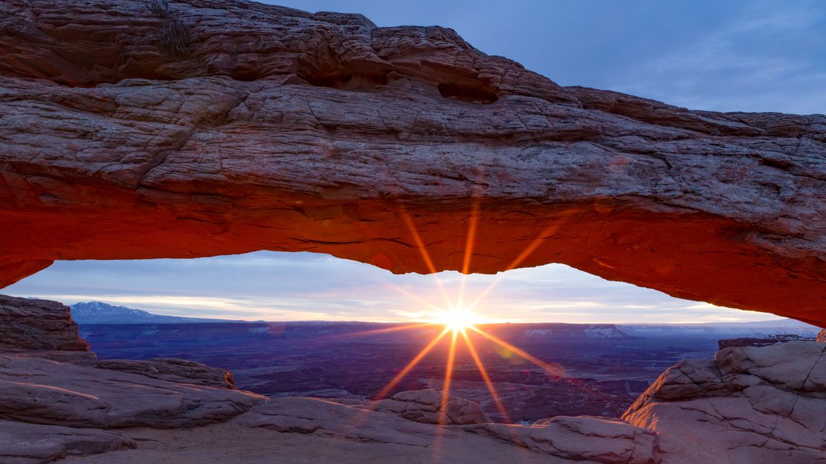 The sun peeking through Mesa Arch in Moab