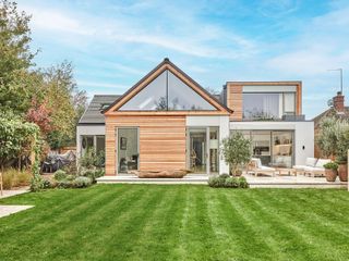 extended and renovated house with a large garden with lawned area and a patio with outdoor sofas