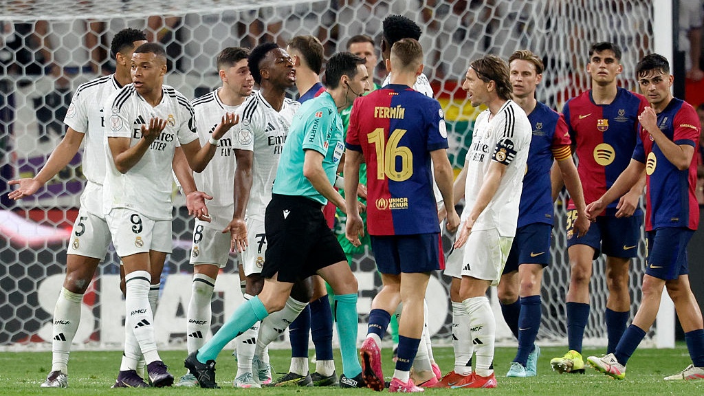 Real Madrid's Croatian midfielder #10 Luka Modric (R) and teammates remonstrate with Spanish referee Ricardo De Burgos Bengoetxea during their Spanish Cup, Copa del Rey (King's Cup) final football match between FC Barcelona and Real Madrid CF at La Cartuja stadium in Seville on April 26, 2025. 