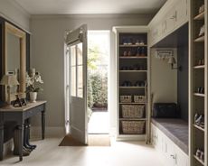 A mudroom with floor-to-ceiling storage and a boot bench with overhead cupboards