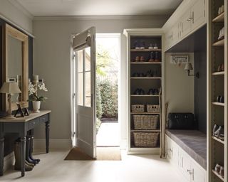 An example of mudroom storage ideas showing a mudroom with floor-to-ceiling storage and a boot bench with overhead cupboards