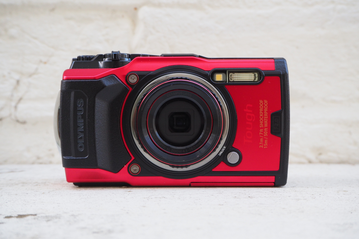 Punainen Olympus TG-6 -kamera valkoisella pinnalla