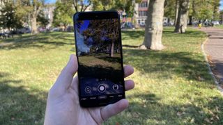 A Google Pixel 5 from the front, in someone's hand, displaying the camera viewfinder