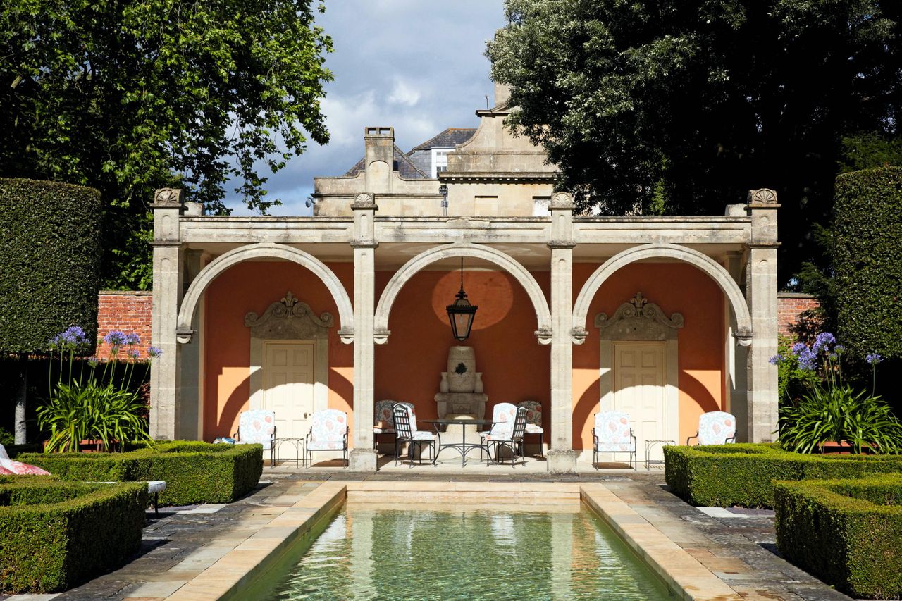 The &#039;Italy&#039; quadrant of the garden at Seend Manor, Wiltshire, with pool house and fountain, a copy of one in Trastevere, Rome, built around 1820s with reclaimed stone loggia pillars and arches.