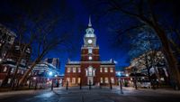 a building with a tower and a clock on it at night.