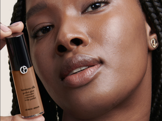 Close up of an African American woman posing with the Giorgio Armani Luminous Silk Concealer
