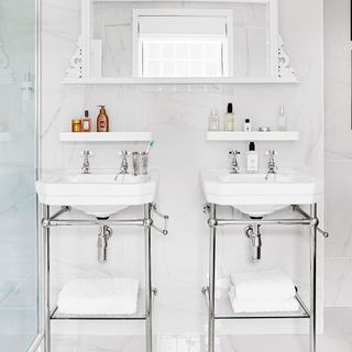 White and chrome bathroom with twin Victorian basins and stands