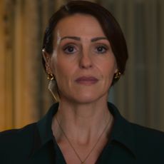 suranne jones wearing a suit with a wire in her ear in hostage