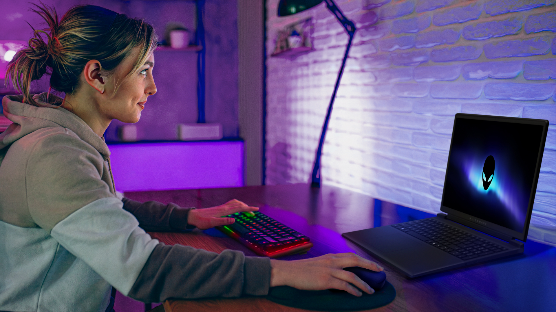 A woman smiles as she uses her Alienware 15 laptop