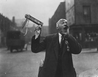 A West Bromwich Albion FC fan cheers as he makes his way to Wembley Stadium for the FA Cup final in 1935