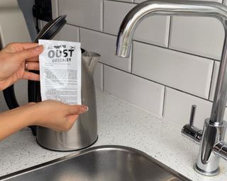 Christina Chrysostomou using sachet of Oust all-purpose descaling treatment to clean an electric kettle