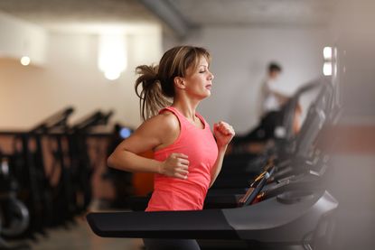 Woman running on treadmill at a gym