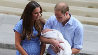 Prince William and Kate Middleton holding a baby Prince George