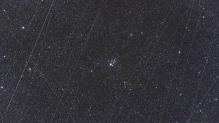 streaks of light crisscross a starry night sky