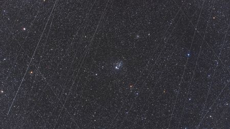 streaks of light crisscross a starry night sky