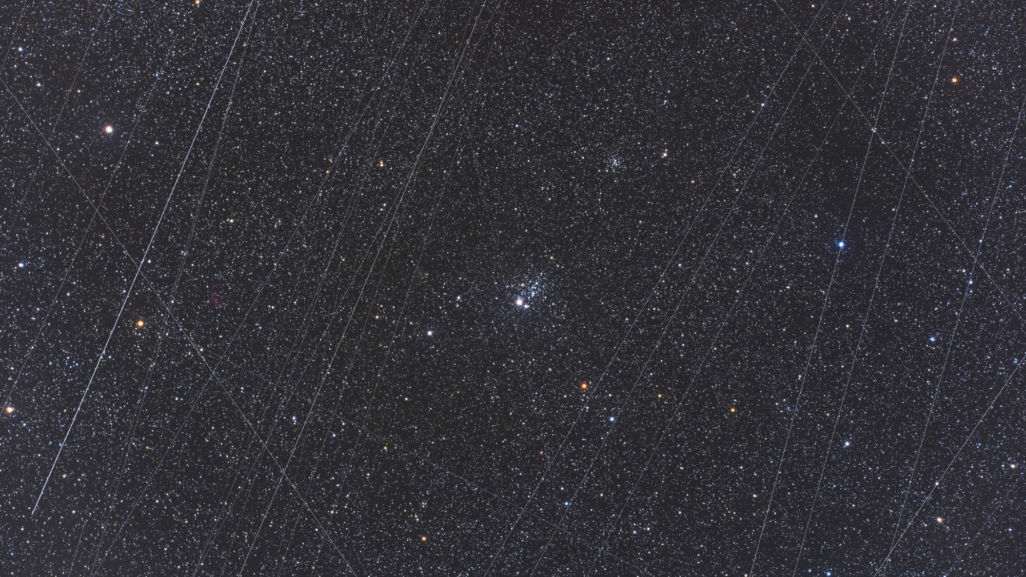 streaks of light crisscross a starry night sky