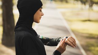 Woman checking her fitness tracker in a park