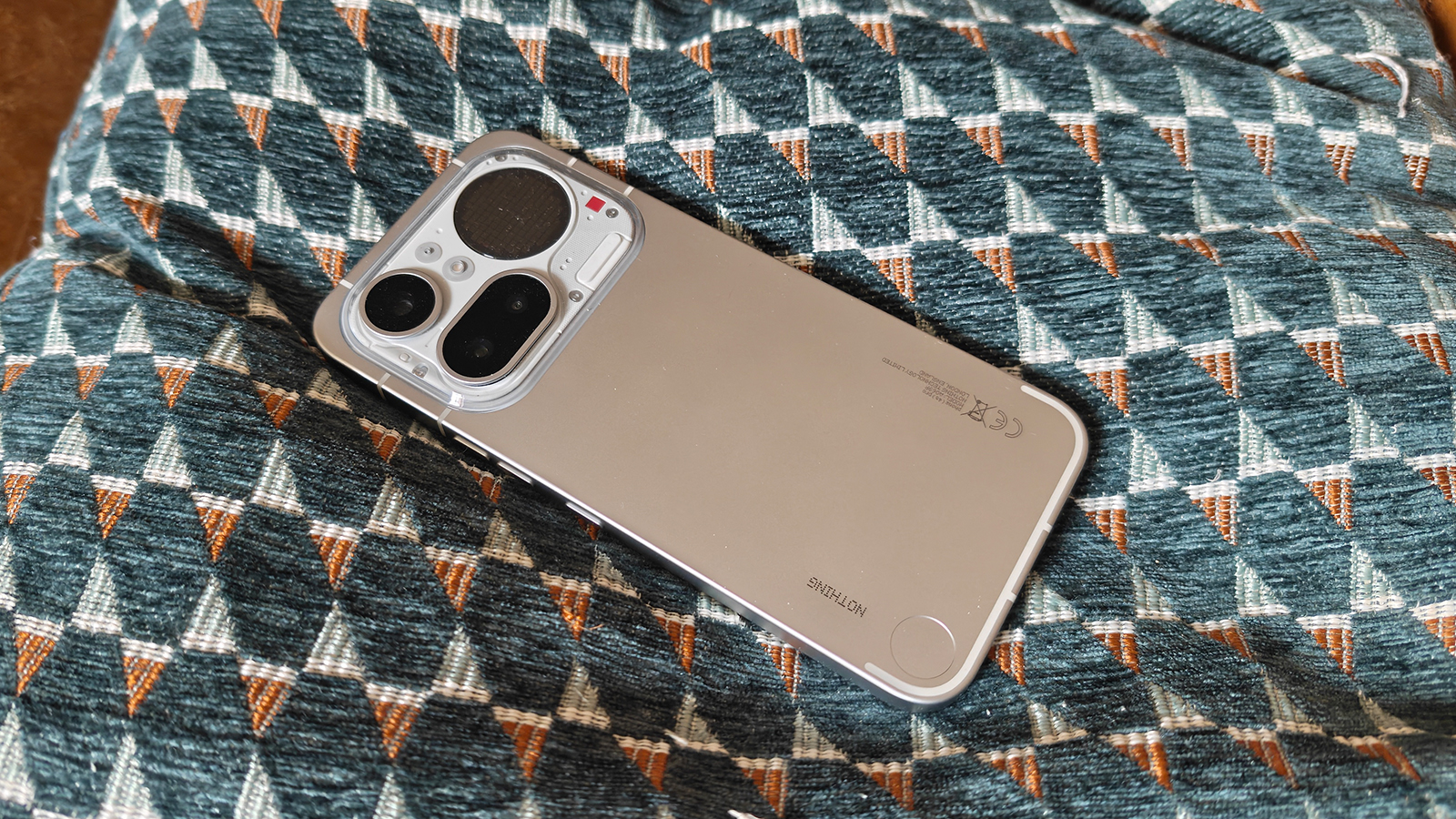 Photos of a silver phone on a cushion