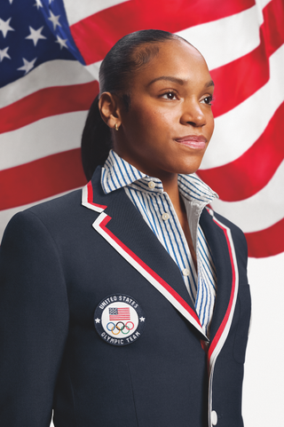 Shilese Jones wears the Ralph Lauren Olympics Opening Ceremony uniform in front of the American flag