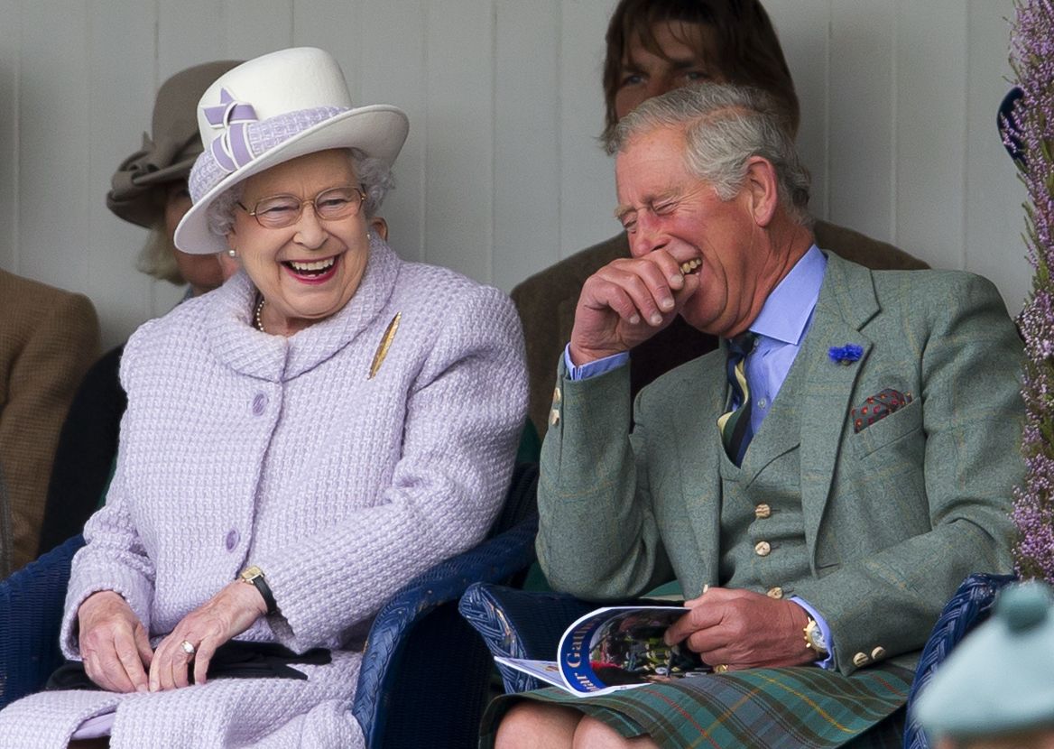 Queen Elizabeth II and Prince Charles, Prince of Wales laugh whilst watching the children&#039;s sack race as they attend the 2012 Braemar Highland Gathering