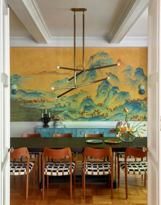 Dining room with tropical mural, rich wood chairs and black table