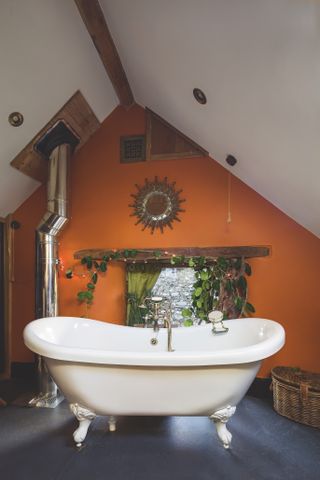 The vaulted ceiling of the converted hayloft provides a charming bedroom on the first floor. The bath, from Victorian Plumbing, sits perfectly in the characterful bathroom.