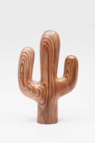 A wooden cactus against a white background.