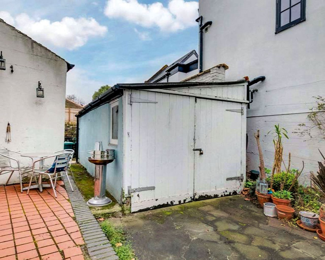 Before shot of a patio with old shed