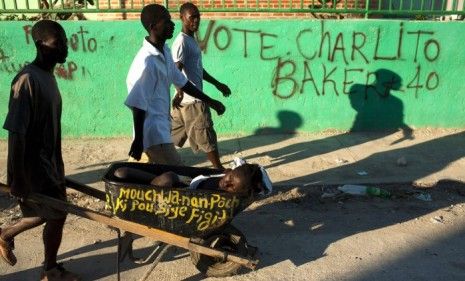 A woman is carried to a nearby hospital in the Haitian city of Gonaives; nearly 15,000 people have been hospitalized since the October cholera outbreak.