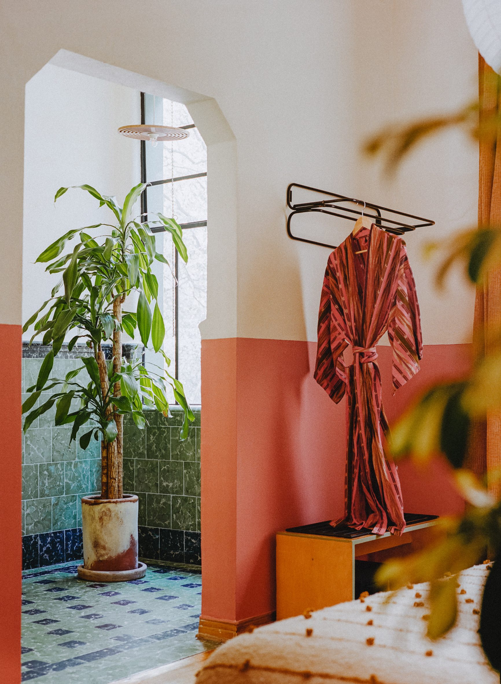 A vibrantly decorated hotel featuring a pastel palette of pinks, greens, and browns, tiled surfaces, and a vaguely Art Deco, contemporary feel.