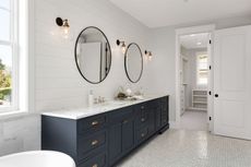 a modern white bathroom with a double sink and two mirrors and a blue vanity, to illustrate the best bathroom paints