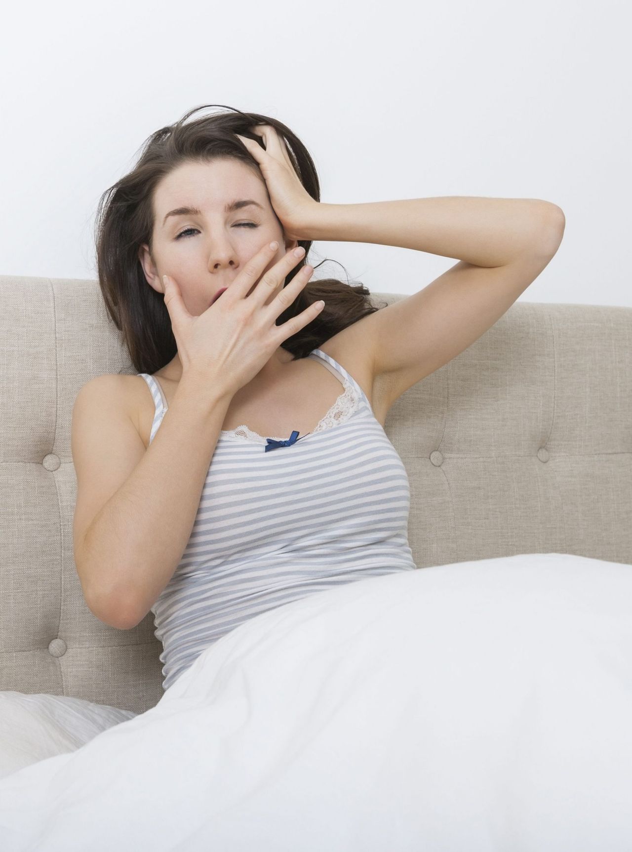 Woman yawning in bed