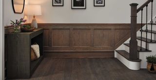 dark wood stained entry wall with neutral walls to showcase a leading flooring trend for 2023 of darker wood tones