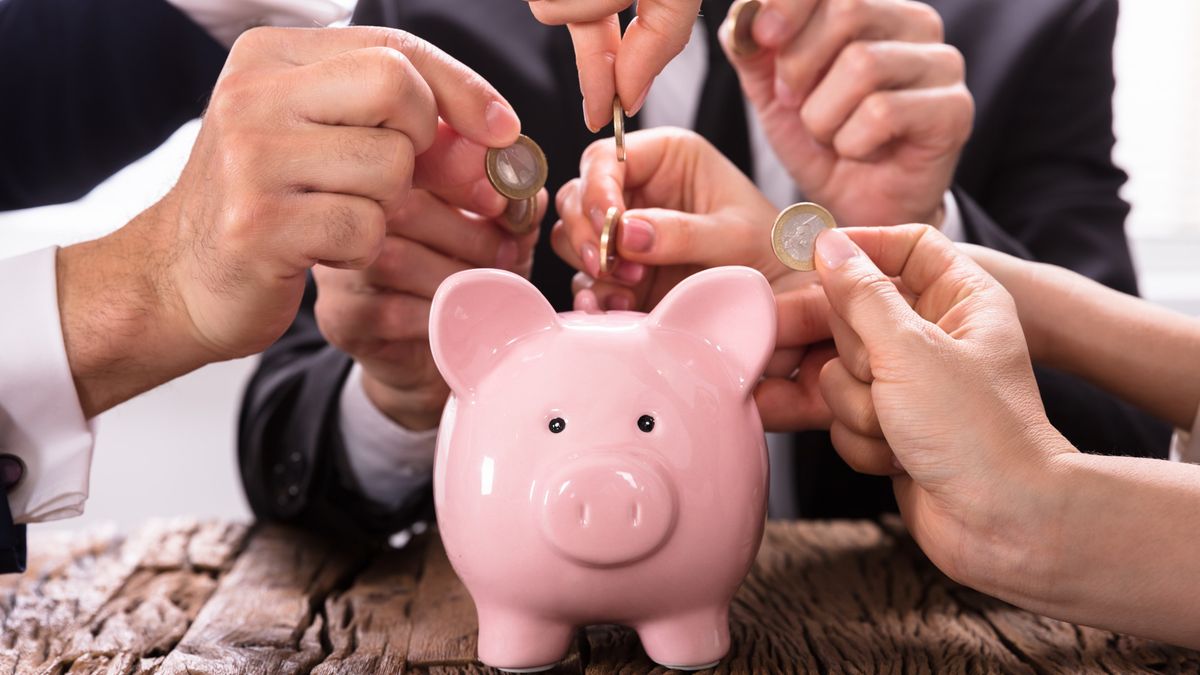 People in business suits adding cash to a piggy bank